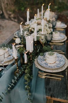 a table topped with lots of plates and candles