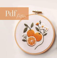 an embroidery project with oranges and flowers on it