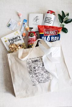 a tote bag filled with snacks and candy on top of a white table cloth