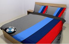 a bed with a bmw logo on the cover and pillow cases in front of it