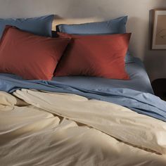 two red and blue pillows on top of a bed