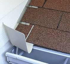 an open laptop computer sitting on top of a roof with gutter attached to it