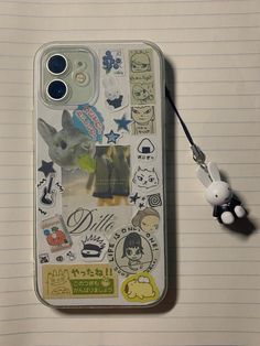 an iphone case with various stickers on it and a cell phone cord attached to the back