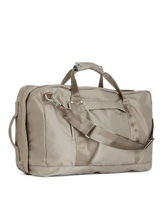 a duffel bag with straps on the handles and shoulder straps, in beige