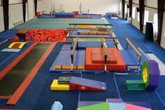 an indoor trampoline park with many different colored surfaces and obstacles on the floor