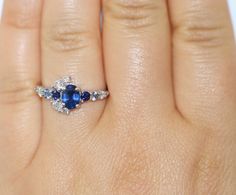 This Enchanting Ring features an oval shape 1.2 carat Blue Sapphire. Flanked by .30 carat 2 shiny deep blue sapphires, .20 carat aqua color 2 sapphires, .40 carat 7 Ice Gray Diamonds. Set in 14k white gold. Can be custom made in rose or yellow or white gold. Please choose the gold color at checkout. OOAK (one-of-a-kind) ring makes you the owner of something that nobody else has. Find your true style! Own this ring! Ethical Sourcing: This ring has a natural, ethically-sourced stones and recycled Half Moon Engagement Ring, Moon Halo, Moon Engagement Ring, Engagement Ring Custom, Marquise Engagement Ring, Crescent Ring, Ring Pop, Custom Wedding Band, Engagement Rings Marquise