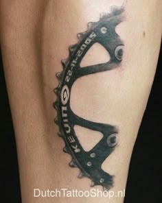 a close up of a person's leg with a bike chain tattoo on it