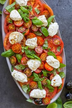 a platter filled with tomatoes, mozzarella and basil