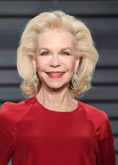 an older woman in a red dress smiling at the camera