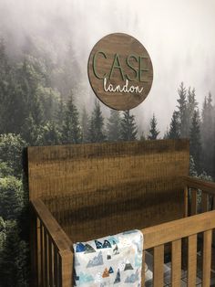 a baby crib in front of a forest scene with the name case lanon on it