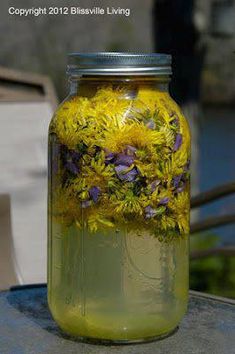 a jar filled with yellow flowers sitting on top of a table