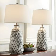 two lamps sitting on top of a table next to a bowl with succulents in it