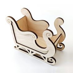 a wooden toy sleigh sitting on top of a white table