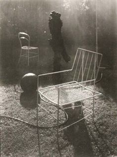 an old photo of a chair and table in the grass