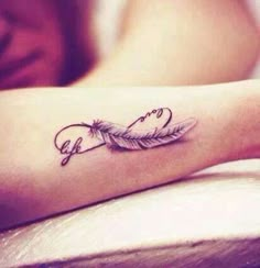 a woman's arm with a tattoo on it that has a feather and the word love written in cursive writing