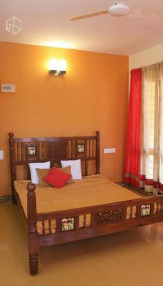 a bed room with a neatly made bed and red curtains