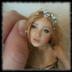 a close up of a doll wearing a tiara with pearls on it's head