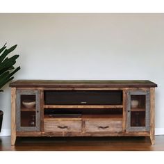 a wooden entertainment center with two drawers and a flat screen tv mounted on top of it