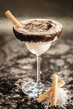 a drink in a glass with some crackers on the rim