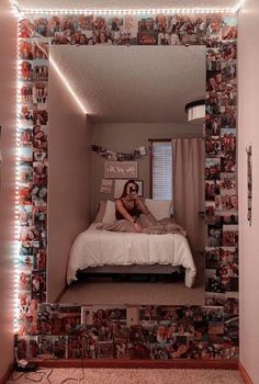 a woman sitting on top of a bed in front of a mirror with lights above it