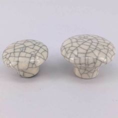 two white ceramic knobs with black and white designs