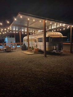 an rv parked under a covered area with lights strung from it's roof and on the ground