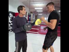 two men standing next to each other holding yellow frisbees