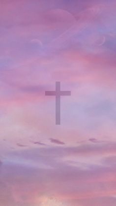 a cross in the middle of a purple and blue sky with clouds behind it at sunset