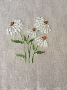 a close up of a piece of cloth with white flowers on it and ladybugs