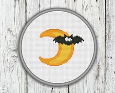 a cross stitch pattern with the letter c in it's center and a bat on top