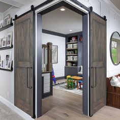 an open door leading into a living room with pictures on the wall and wooden floors