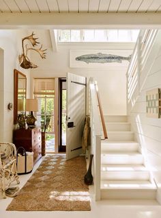 an entry way with white walls and wooden steps leading up to the second floor area