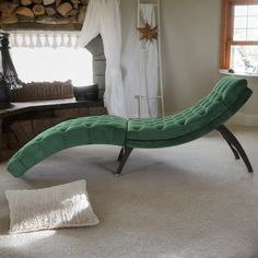 a green chaise lounger sitting on top of a white carpeted floor next to a window