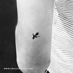 a black and white photo of a small airplane tattoo on the left inner arm,