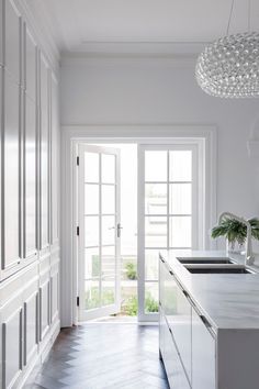 a kitchen with white cabinets and an open door