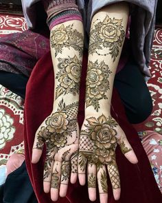 two hands with henna tattoos on them