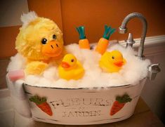 a stuffed duck and two rubber ducks in a tub