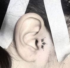 a woman's left ear is shown with two small black dots on the side