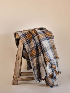 a plaid blanket draped over an old wooden stool