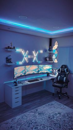 a computer desk with two monitors on top of it in front of a blue wall