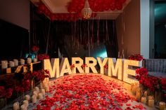 a room filled with lots of red flowers and candles next to a marquee