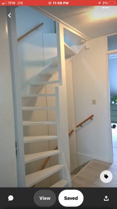 an empty room with stairs leading up to the second floor and another door in the background