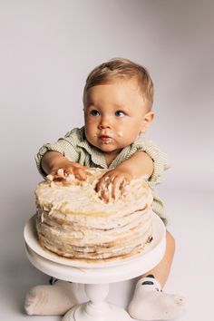 a baby sitting in front of a cake