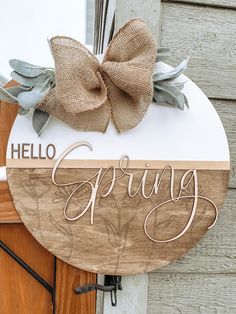 a wooden sign that says spring with a bow on it's head and the words hello spring written in cursive writing