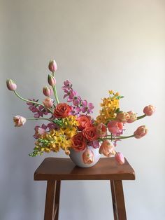 a vase filled with flowers sitting on top of a wooden table