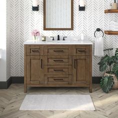 a bathroom vanity with two sinks and a mirror on the wall next to a potted plant