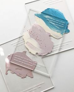 three acrylic colors are on top of a clear plastic plate with some writing