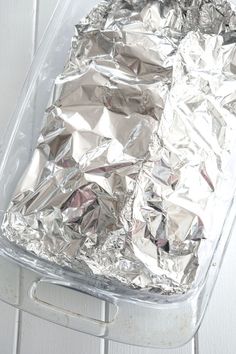 an aluminum foil covered dish sitting on top of a metal rack