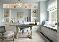 a home office with white cabinets and blue chairs