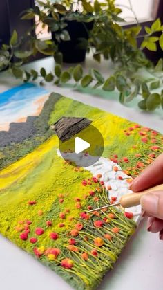 someone is painting flowers on a piece of paper